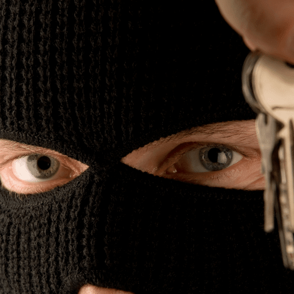 Keeping Your Home Secure While It is on the Market - a ski-masked man holding out a set of keys